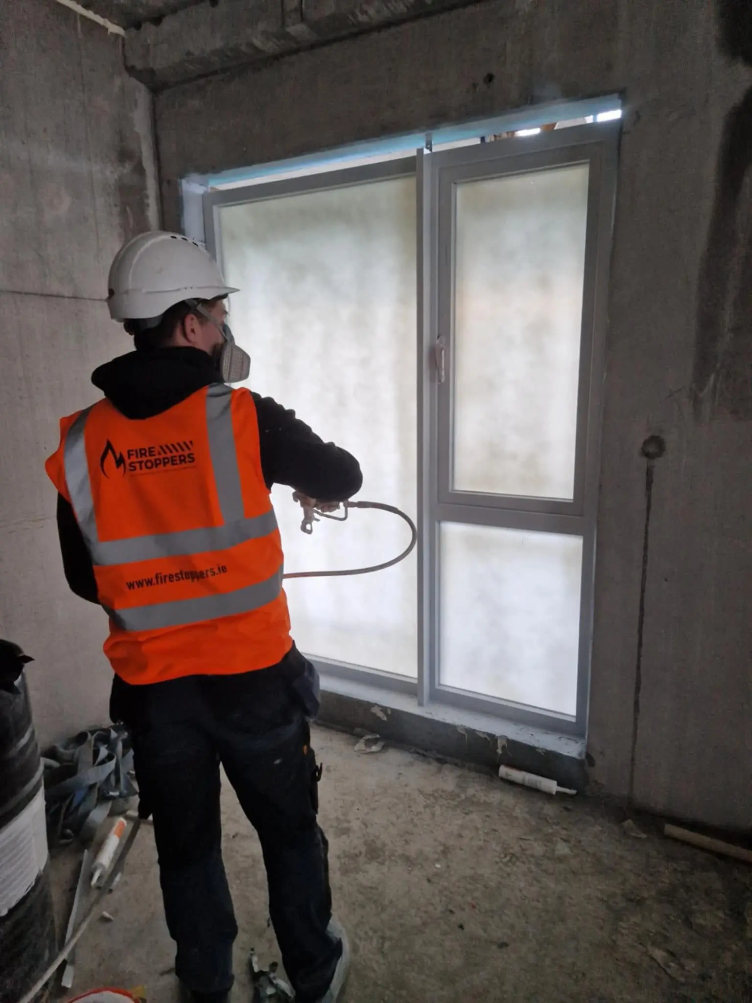 A firestoppers team member applying Omniguard Window Protection