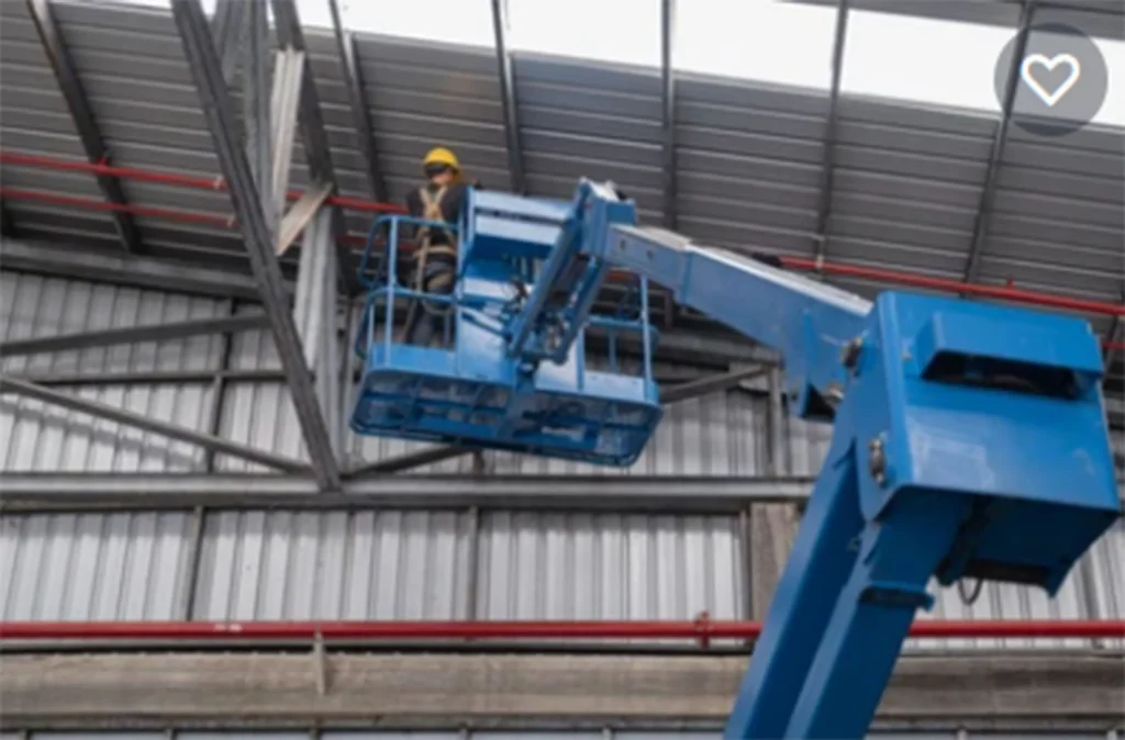 man standing on an elevating platform working on roof fire safety measures | About Us | Firestoppers