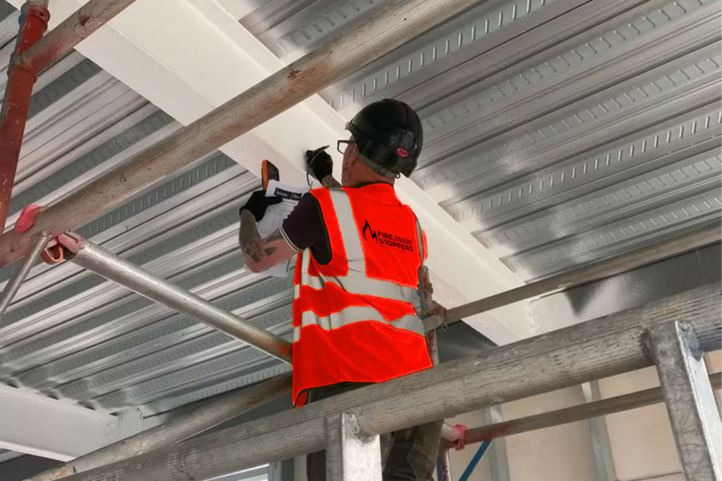 image of a fire safety consultant placing intrumescent coatings on a commerial structure in dublin