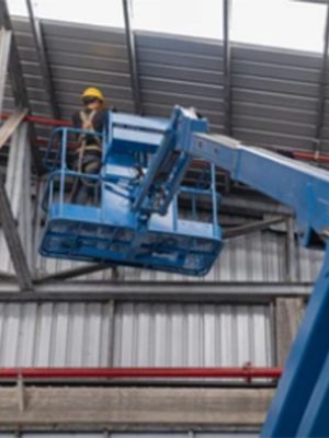 man standing on an elevating platform working on roof fire safety measures | About Us | Firestoppers